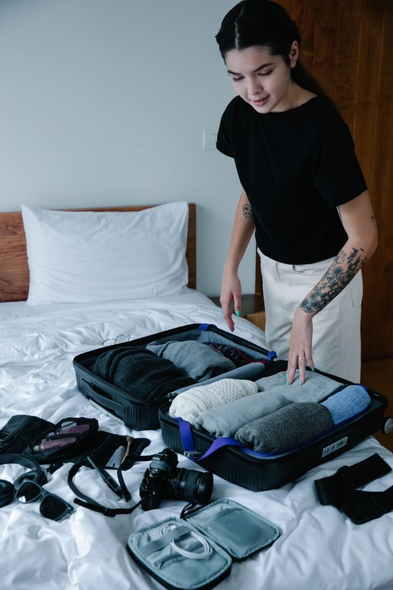 Flat lay of suitcase + passport + charger + packing cubes.