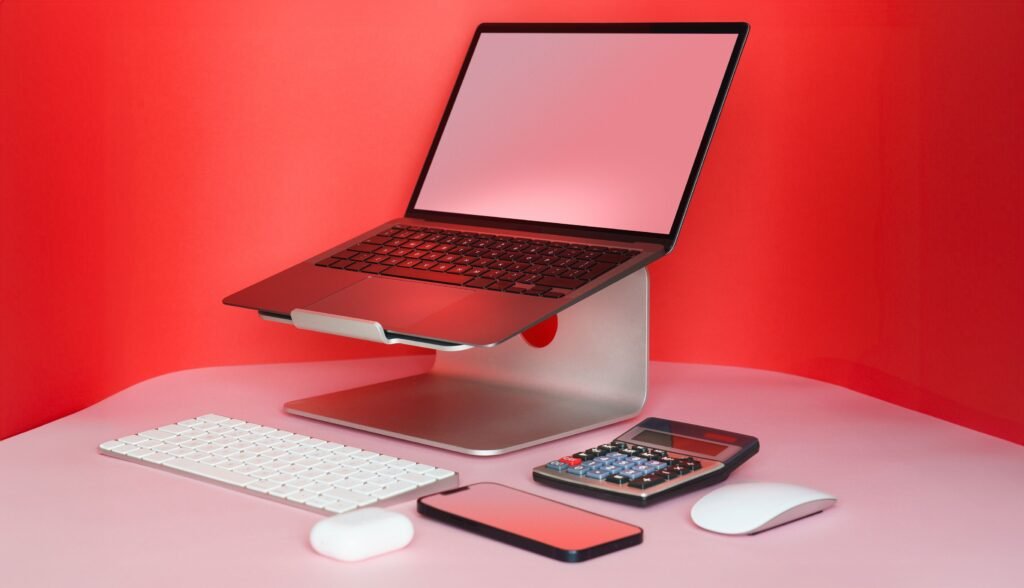Premium hard shell ergonomic laptop case packed next to a portable aluminium laptop stand on a wood table.